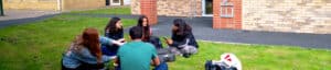 students sitting and discussing their work outside Impington International college